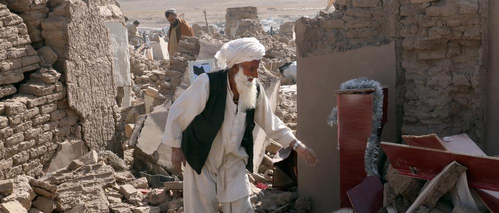 Ein Mann steht in Afghanistan den Trümmern seines Hauses.