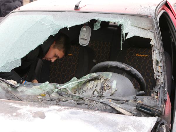 Ein Anwohner inspiziert ein beschädigtes Auto, das im Zuge des russisch-ukrainischen Konflikts in der Siedlung Rasumnoje in der Region Belgorod am 19. März 2024 von einem Beschuss getroffen wurde.