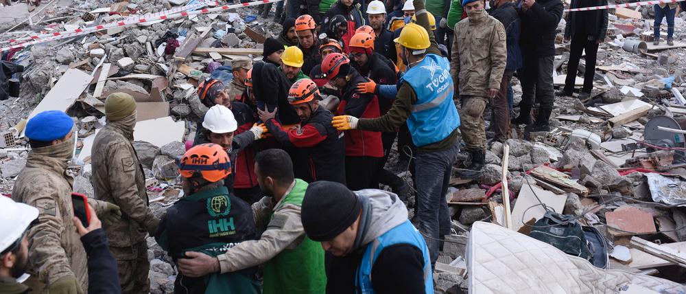 Einsatzkräfte tragen einen Überlebenden aus den Trümmern. 