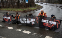 Sitzen statt schwitzen: Aktivisten am Morgen bei der Blockade der Autobahnzufahrt in Steglitz. Foto: Paul Zinken/dpa