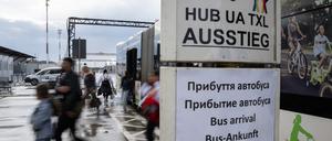 Menschen steigen aus dem BVG-Shuttel und gehen an Schildern mit Informationen auf Deutsch und Ukrainisch vorbei. Die Flüchtlingsunterkunft auf dem ehemaligen Flughafen Tegel beherbergt rund 2500 Menschen. (zu dpa «Berliner Senatorin stellt Verteilmechanismus für Flüchtlinge infrage») +++ dpa-Bildfunk +++