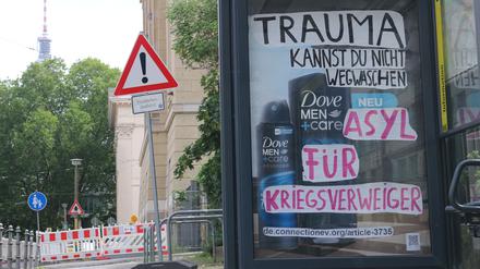Auf ein Plakat für Duschgel schrieben die Aktivist:innen: „Trauma kannst Du nicht wegwaschen. Asyl für Kriegsverweiger“ (sic).
