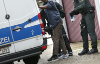 Polizisten bei einer Razzia in einer Gemeinschaftsunterkunft für Asylbewerber in Mengen (Baden-Württemberg) Foto: dpa/Thomas Warnack