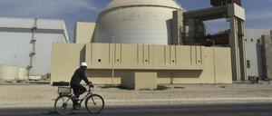 Ein Arbeiter fährt mit seinem Fahrrad vor dem Reaktorgebäude am Atomkraftwerk Buschehr (Archivbild). 