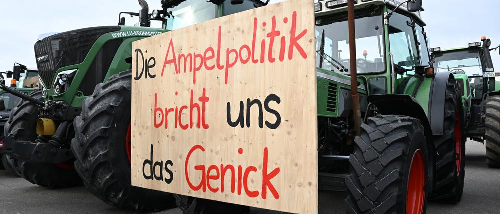 Mit Traktoren und einem Transparent mit der Aufschrift: „Die Ampelpolitik bricht uns das Genick“ demonstrieren Landwirte auf dem Cannstatter Wasen gegen die Agrarpoltik der Bundesregierung.