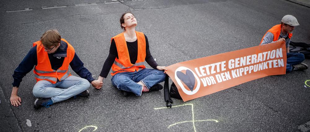 Aktivisten der Organisation „Letzte Generation“ blockieren eine Straße.