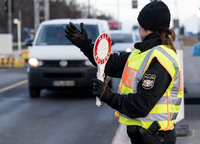 Ein Polizistin winkt an einer Kontrollstelle Fahrzeuge, die aus Österreich kommen, für eine Kontrolle aus dem Verkehr. Foto: dpa