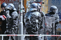 Mit Farbbeuteln beworfene Polizei stehen vor der teilbesetzten Rigaer Strasse 94. Foto: imago images/Bernd Elmenthaler
