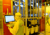 Ein Bosch-Mitarbeiter in der neuen Halbleiterfabrik im Reinraum an einer Maschine für die Bestückung von 300-Millimeter-Wafern. Robert Michael/dpa-Zentralbild/dpa