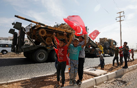 Junge Türken jubeln bei der Vorbeifahrt eine Militärkonvois auf dem Weg nach Syrien. Foto: Reuters/Kemal Aslan