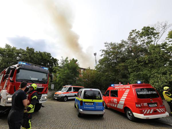 Feuerwehr und Ordnungsamt vor dem Alten Landtag. Dahinter steigt eine Rauchsäule empor. 
