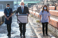 Boris Johnson mit einer Kiste des Impstoffs von Astrazeneca Foto: Stefan Rousseau/REUTERS