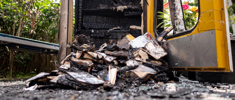 Verbrannte Bücher liegen in der ausgebrannten Bücherbox in der Nähe des Mahnmals „Gleis 17“. 