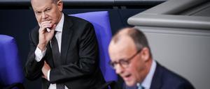 Friedrich Merz (CDU) spricht neben Bundeskanzler Olaf Scholz (l, SPD) im Bundestag.