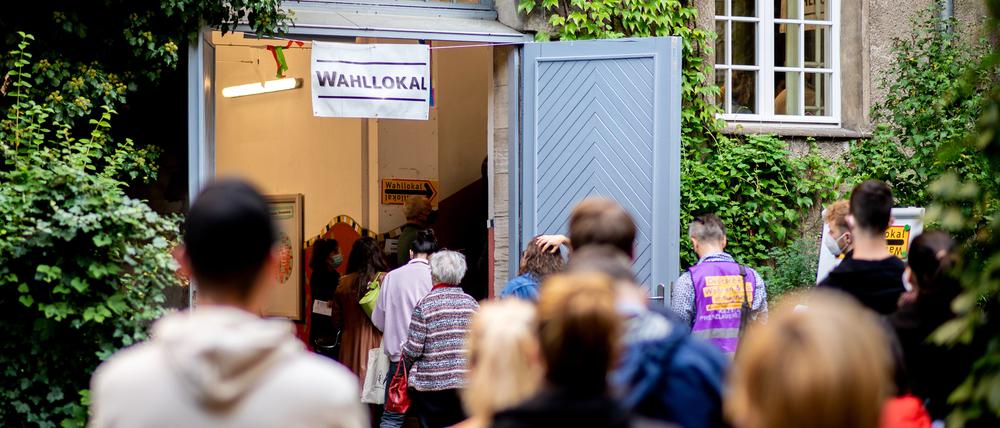 Zahlreiche Wählerinnen und Wähler warten im Stadtteil Prenzlauer Berg in einer langen Schlange vor einem Wahllokal, das in einer Grundschule untergebracht ist. 