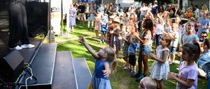 Singa (l) vom Kindersender Kika tanzt und singt mit Kindern beim Tag des offenen Schlosses von Bundespräsident Steinmeier im Park von Schloss Bellevue.