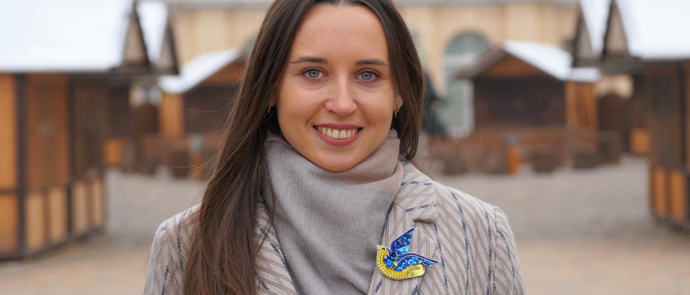 Iryna Bushmina aus Kiew assistiert dem Veranstalter des Berliner Weihnachtsmarkts vor dem Schloss Charlottenburg.