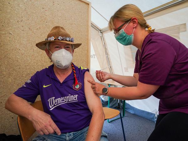 Ein Fan des FC Erzgebirge Aue erhält von der Impfschwester Carolin Mühlmann seine Erstimpfung im Erzgebirgstadion Aue. 