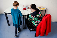 Ein Mädchen arbeitet mit ihrer Nachhilfelehrerin in einem Aufgabenheft. Foto: Uwe Anspach/dpa