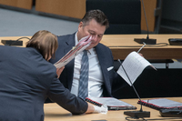Platz machen zum Putzen: Der Tisch von Innensenator Andreas Geisel (SPD) im Berliner Abgeordnetenhaus wird gereinigt. Foto: Jörg Carstensen/dpa