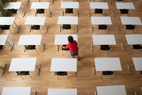 Eine Frau bereit in der Aula im Sorbischen Gymnasium Bautzen Tische und Stühle für die bevorstehenden Abschlussprüfungen vor. Foto: Sebastian Kahnert/dpa-Zentralbild/dpa