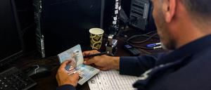Ein palästinensischer Grenzbeamte überprüft den Pass eines US-Bürgers.