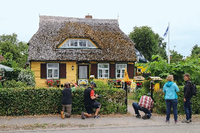 Neben endlos langen Stränden bietet Ahrenshoop auch Rohrdachhäuser in den verschiedensten Farben, in diesem Fall in Gelb mit einem Briefkasten in Hausform. Foto: Nadja Bossmann