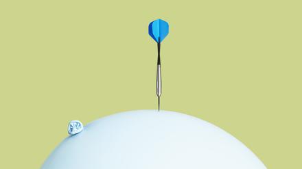 Ein Dartpfeil trifft auf einen Luftballon.