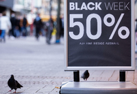 "Black Week 50%" steht auf einem Aufsteller vor einem Geschäft auf der Hohe Straße. Foto: dpa/Rolf Vennenbernd