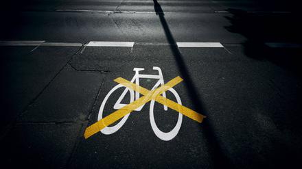 Das Piktogramm für einen Radweg in der Ollenhauerstraße in Berlin Reinickendorf wurde mit einer gelben Markierung durchkreuzt. 