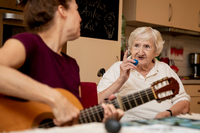 Musik regt das Gedächtnis an. Daher sing Musiktherapeutin Julia Pohl (links) mit Almute Hohensee in einer Demenz-Wohngemeinschaft in Berlin-Neukölln. Foto: Christoph Soeder/dpa