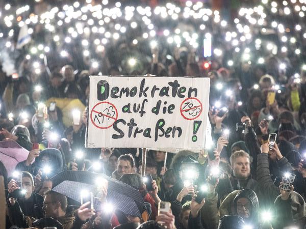 Menschen nehmen in Darmstadt bei strömendem Regen an einer Demonstration gegen Rechtsextremismus und die AfD teil (23. Januar 2024).