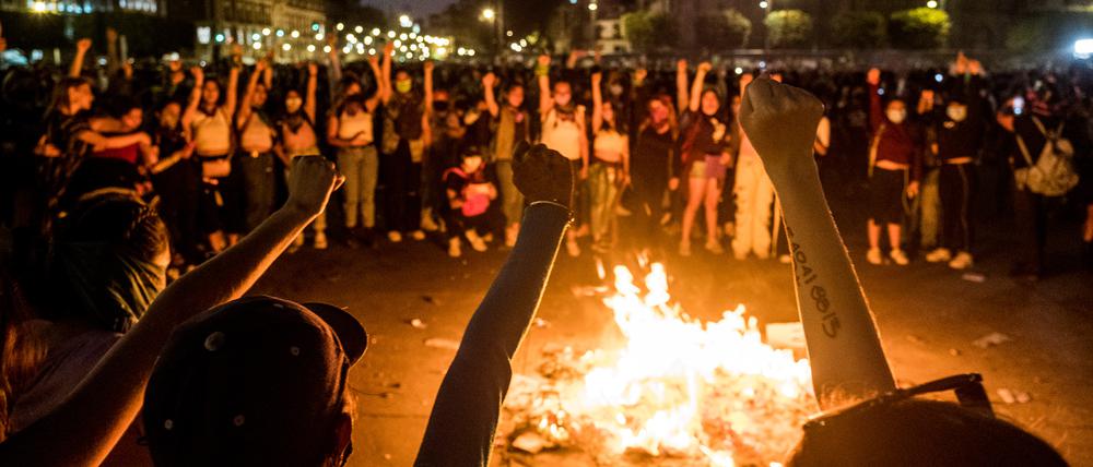 Demonstrierende Frauen versammeln sich um ein Feuer am Zocalo in Mexiko City, Mexiko.