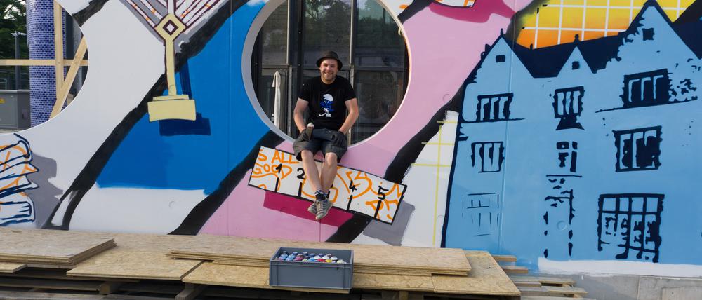 Der Künstler Tobo vor der jüdischen Graffitiwand am Pears Jüdischer Campus