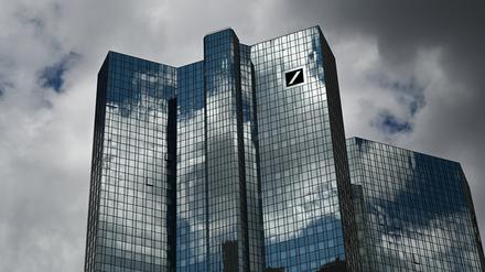 Wolken ziehen über die Zentrale der Deutschen Bank, während sich der Wolkenhimmel in der Fassade spiegelt. 