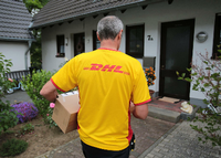 Ein DHL-Paketzusteller der Deutschen Post liefert in Königswinter (Nordrhein-Westfalen). Foto: Oliver Berg/dpa