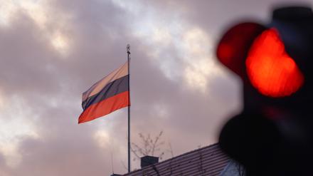 Die Flagge der Russischen Botschaft weht am frühen Morgen hinter einer roten Ampel. 