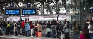 Bahnreisende warten auf dem Bahnsteig auf die Einfahrt des Zuges im Kölner Hauptbahnhof. 