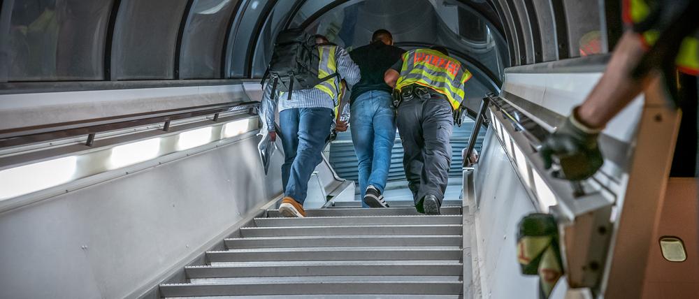 Polizeibeamte begleiten einen Afghanen auf dem Flughafen Leipzig-Halle in ein Charterflugzeug. 45 abgelehnte Asylbewerber wurden mit dem Sonderflug in Afghanistans Hauptstadt Kabul abgeschoben.
