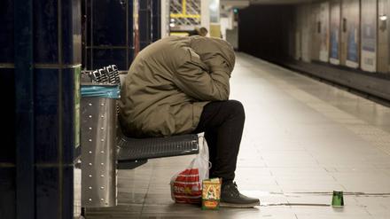 Ein Obdachloser sitzt auf einer Bank in einem U-Bahnhof in Neukölln.