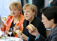 Alles Wurst? Angela Merkel (Mitte) beim Fest der Thüringischen Landesvertretung am Montagabend - kurz vor dem Koalitionsgipfel im Kanzleramt. Foto: dpa