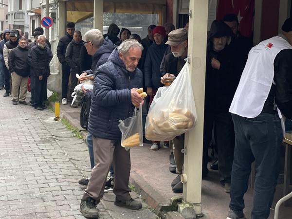 Ein Mann holt sich Brot zu seiner Suppe. 150 Obdachlose versorgt Imam Osman hier jeden Samstag.