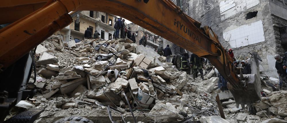 Mitarbeiter des syrischen Zivilschutzes und Sicherheitskräfte durchsuchen die Trümmer eingestürzter Gebäude in Aleppo.