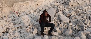 Der 15-jährige Muhammad Al-Mula sitzt in der Nähe seines zerstörten Hauses, das durch das Erdbeben an der türkisch-syrischen Grenze zerstört wurde. 