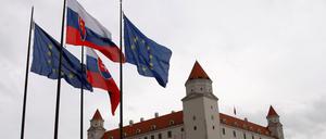 Slowakische und EU-Flaggen vor dem Parlamentsgebäude.