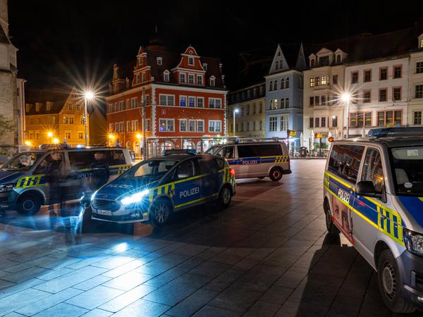 Fahrzeuge der Polizei stehen vor dem Marktschlösschen (rotes Gebäude) auf dem Marktplatz in Halle/Saale