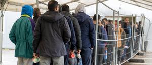 In der Landeserstaufnahmestelle warten Flüchtlinge in einer Schlange vor der Essensausgabe. 
