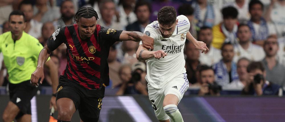 Real Madrid's Uruguayan midfielder Federico Valverde (R) vies with Manchester City's Swiss defender Manuel Akanji during the UEFA Champions League semi-final first leg football match between Real Madrid CF and Manchester City at the Santiago Bernabeu stadium in Madrid on May 9, 2023. (Photo by Thomas COEX / AFP)