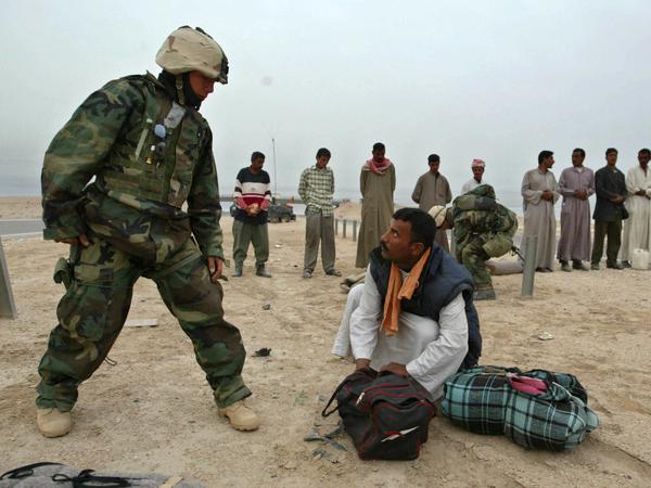US-amerikanische Militärpolizei überprüft die Tasche eines irakischen Mannes nahe Basra (Archivbild von 2003).