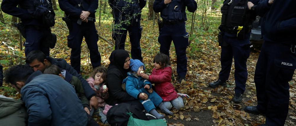 Polnische Grenzbeamte stehen um eine irakische Frau mit Kindern herum: 2021 eskalierte die Lage an der Grenze zu Belarus. 